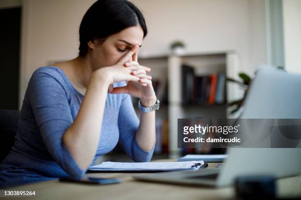 mujer joven exhausta en casa - depresión económica fotografías e imágenes de stock