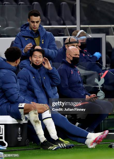 Dele Alli, Son Heung-Min and Sergio Reguilon of Tottenham Hotspur interact on the substitutes bench during the UEFA Europa League Round of 32 match...