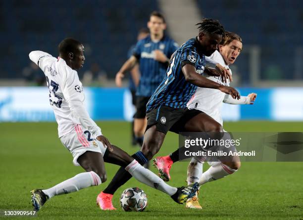 Duvan Zapata of Atalanta is challenged by Ferland Mendy and Luka Modric of Real Madrid during the UEFA Champions League Round of 16 match between...