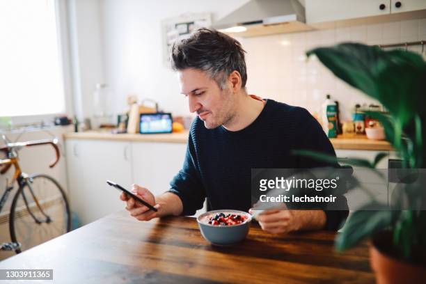 young man having a healthy breakfast - fitness app stock pictures, royalty-free photos & images