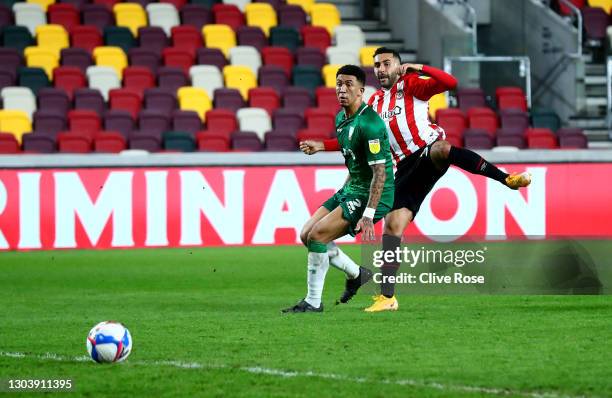 Saman Ghoddos of Brentford scores their side's second goal whilst under pressure from Liam Palmer of Sheffield Wednesday during the Sky Bet...