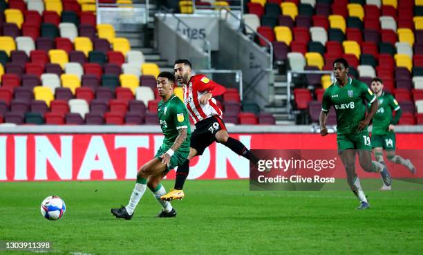 Saman Ghoddos of Brentford scores their side's second goal whilst under pressure from Liam Palmer of Sheffield Wednesday during the Sky Bet...