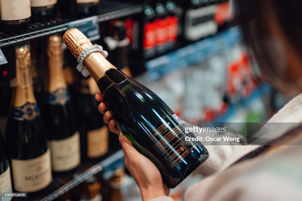 Woman choosing champagne in liquor store