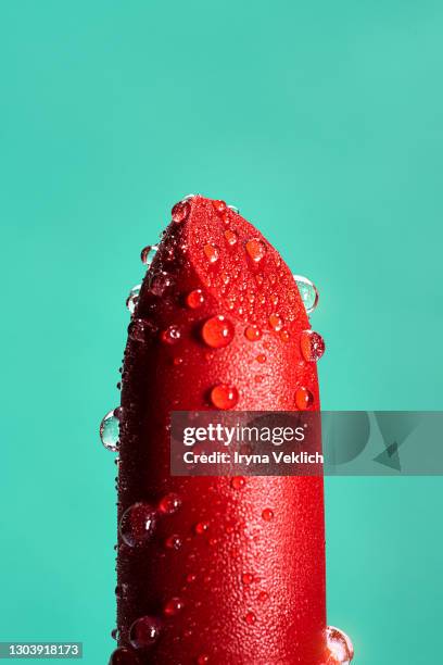 red lipstick with feather on mint green background. - cream mouth stock pictures, royalty-free photos & images