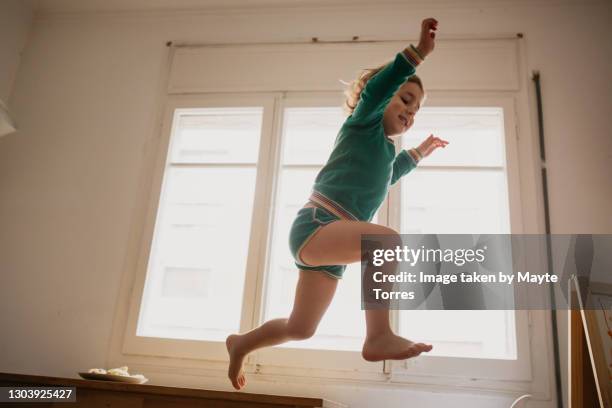 boy jumping from a table - toddler photos et images de collection