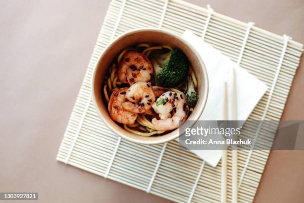 asian traditional fast food: noodles, shrimps and broccoli top view with bamboo chopsticks in paper cup. - japanese food stock pictures, royalty-free photos & images