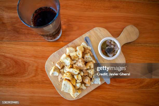 berenjenas en escabeche con trozos de pan tostado y vaso de gaseosa. - gaseosa stock pictures, royalty-free photos & images