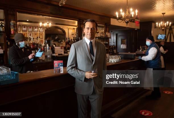 Madame Tussauds Jon Hamm wax figure holds a glass of whiskey by the bar at Peter Luger Steak House to help with social distancing amid the...