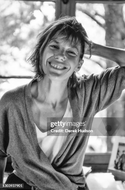 Jane Mallory Birkin, OBE poses in a white T-short and oversize pale blue cardigan for informal portraits at her former home in the 16th...