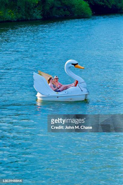couple enjoy a swanboat on lady bird lake, austin, texas - pedal boat stock pictures, royalty-free photos & images