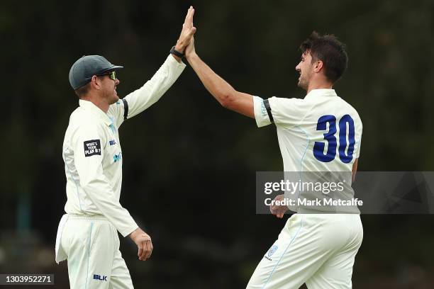 Pat Cummins of the Blues celebrates with team mate Daniel Hughes of the Blues after taking the wicket of Peter Handscomb of Victoria during day one...