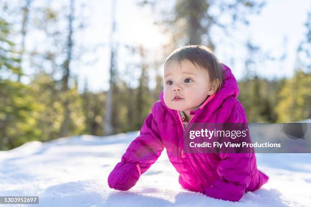 mixed race baby crawling in the snow - winter baby stock pictures, royalty-free photos & images