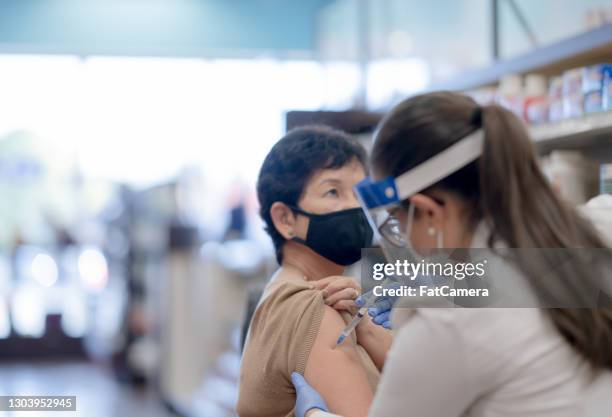 senior woman getting the covid-19 vaccine injection stock photo - covid-19 vaccine stock pictures, royalty-free photos & images