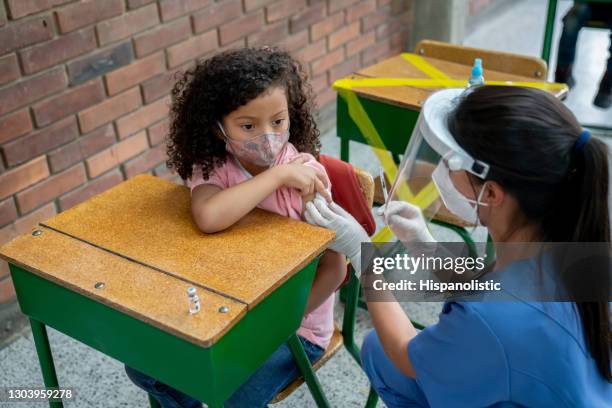 girl getting a covid-19 vaccine at the school - global health stock pictures, royalty-free photos & images