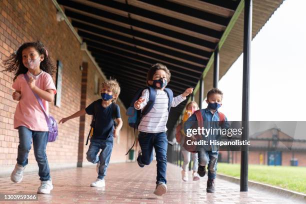 kids running and looking very excited to be back at school while wearing facemasks - latin america covid stock pictures, royalty-free photos & images