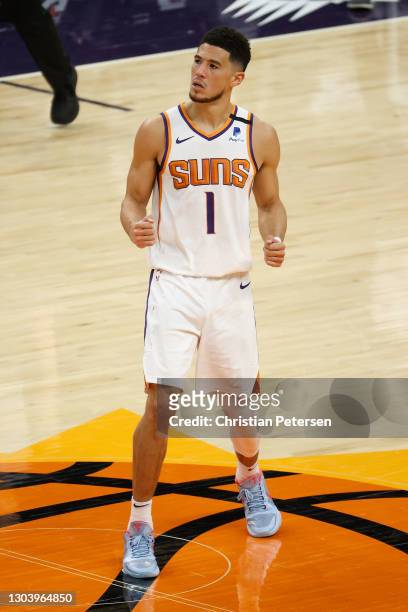 Devin Booker of the Phoenix Suns reacts to a three-point shot during the final moments of the NBA game against the Charlotte Hornets at Phoenix Suns...