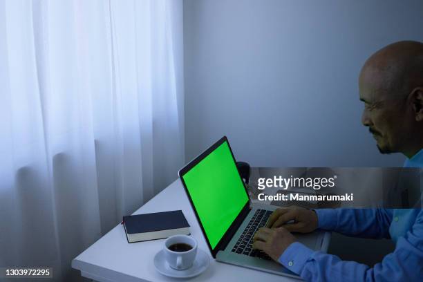 a man who works on a computer at home. - computer monitor green screen stock pictures, royalty-free photos & images