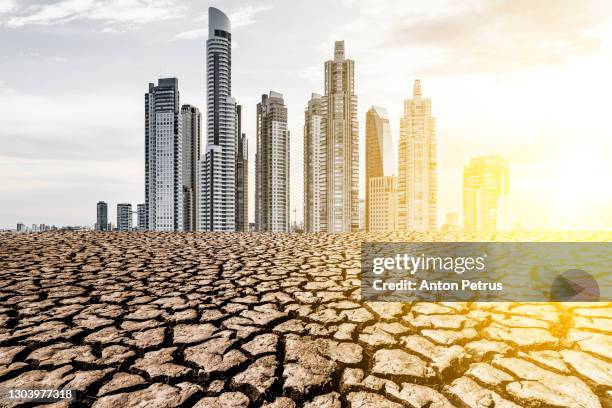 skyscrapers in the desert with cracked earth. the concept of globalization and global warming - qatar desert photos et images de collection