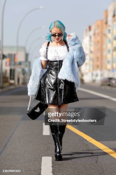 Influencer and Content Creator Naomi Jon wearing vegan black knee high platform 90"u2019s inspired shiny boots by Naked Wolfe, a light blue faux fur...