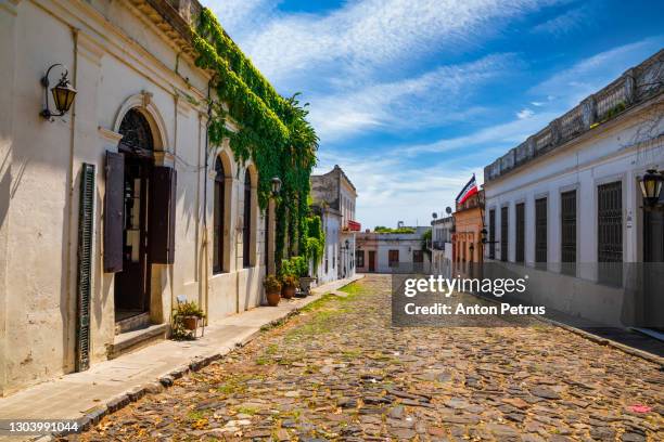 colonial street and houses at summer day. colonia del sacramento. uruguay. - cobblestone pathway stock pictures, royalty-free photos & images