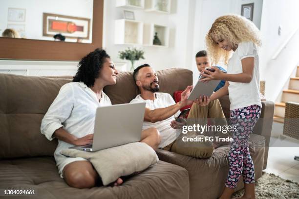 family together at home in the living room using electronical devices - free show stock pictures, royalty-free photos & images