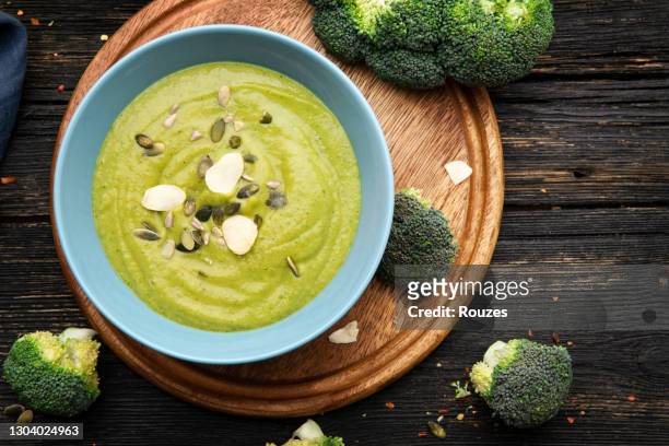 brokkoli-creme-suppe auf holzhintergrund - cremesuppe stock-fotos und bilder
