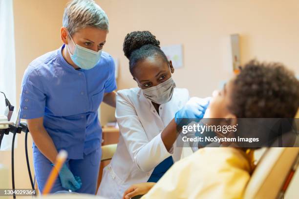 black female dentist doing dental check-up - dental assistant stock pictures, royalty-free photos & images