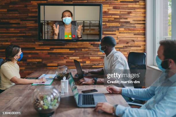 business people meeting on video call in the office during covid-19 pandemic - business meeting with masks stock pictures, royalty-free photos & images