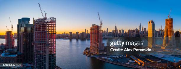 nueva construcción de torres residenciales de lujo en el paseo marítimo de east river en greenpoint, brooklyn, y hunters point, queens, alrededor de newtown creek, con la vista panorámica del horizonte de manhattan. panorama aéreo de alta resolución e - queens new york city fotografías e imágenes de stock