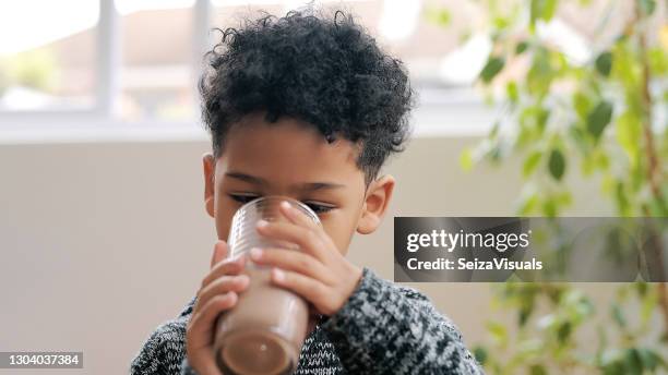 chocolate milk, the official drink of childhood - kid drinking chocolate milk stock pictures, royalty-free photos & images