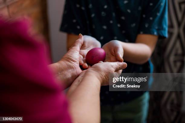 jonge jongen die paasei neemt dat zijn oma hem geeft. selectieve focus. - oosters orthodoxe kerk stockfoto's en -beelden
