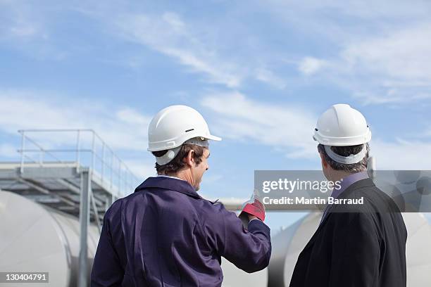 trabalhador e empresário analisar os tanques ao ar livre - macacões - fotografias e filmes do acervo