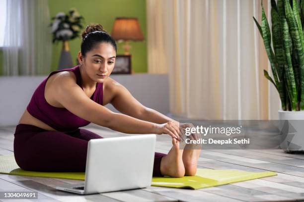 junge frau macht yoga zu hause, stockfoto - touch toes stock-fotos und bilder