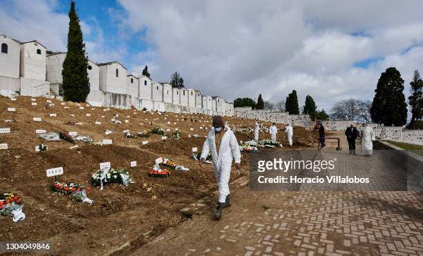 Gravedigger wearing protective gear leaves a gravesite after completing the burial of a COVID-19 victim at Cemitério do Alto de São João during the...