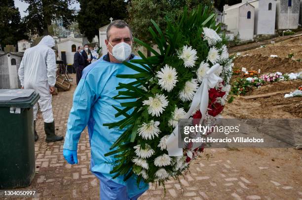 Funeral home employee wearing protective gear for the grave of a COVID-19 victim before burial at Cemitério do Alto de São João during the COVID-19...