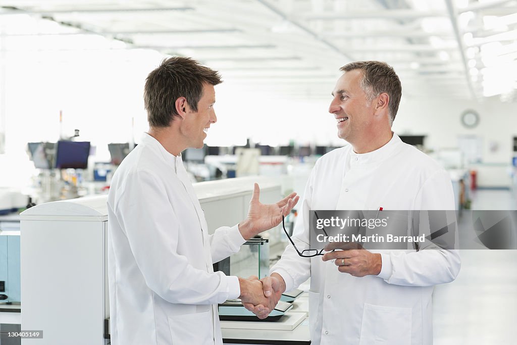 Scientists shaking hands in lab