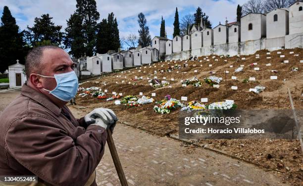 Gravedigger wearing a protective mask pauses while working on the grave of a COVID-19 victim at Cemitério do Alto de São João during the COVID-19...