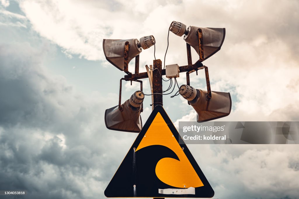 Tsunami warning sign against dramatic sky