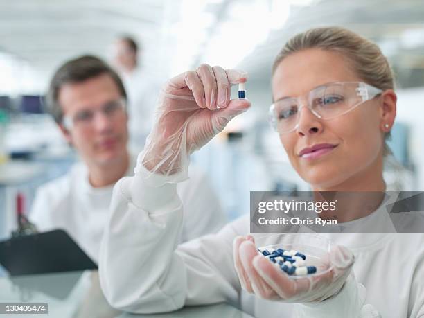 scientists examining pills in lab - medicine dose stock pictures, royalty-free photos & images