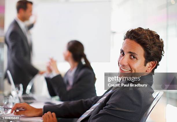 businessman smiling at desk - arrogance stock pictures, royalty-free photos & images