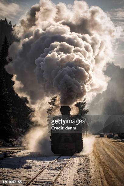 old train with big smoke during winter time in moldovita, bucovina. romaniia. - lokomotive stock-fotos und bilder