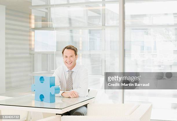 businessman sitting at desk with sculpture - man sitting at a desk craft stockfoto's en -beelden