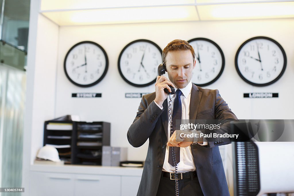Homme d'affaires vérifiant sa montre dans le bureau