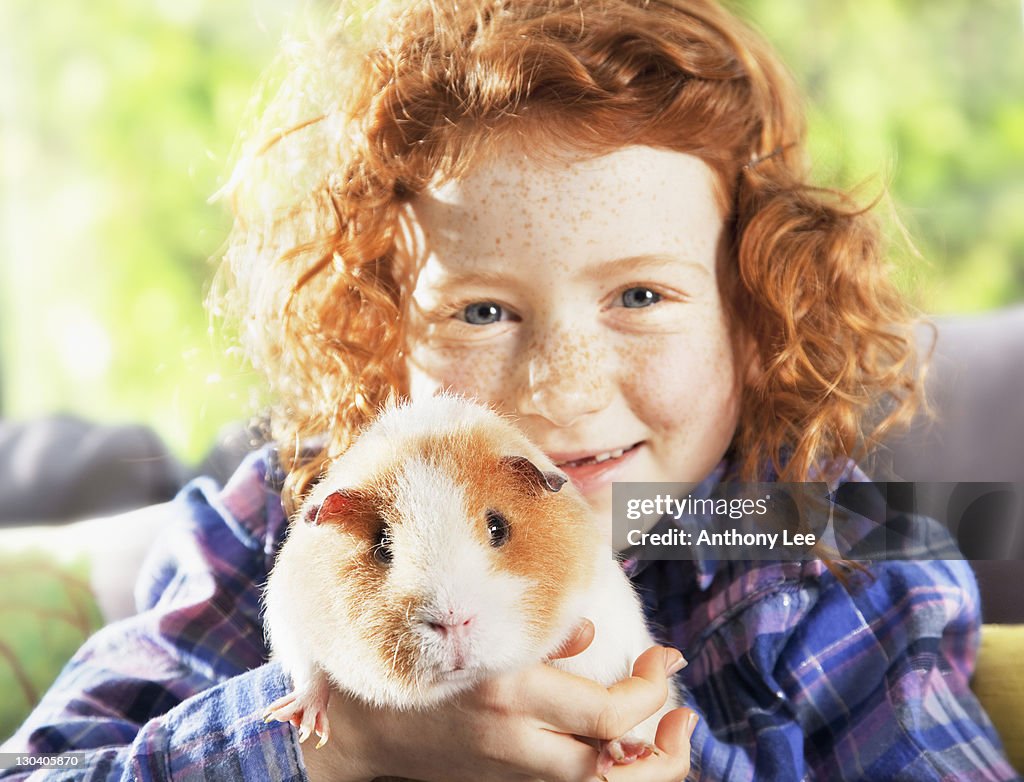 Girl holding pet hamster in living room