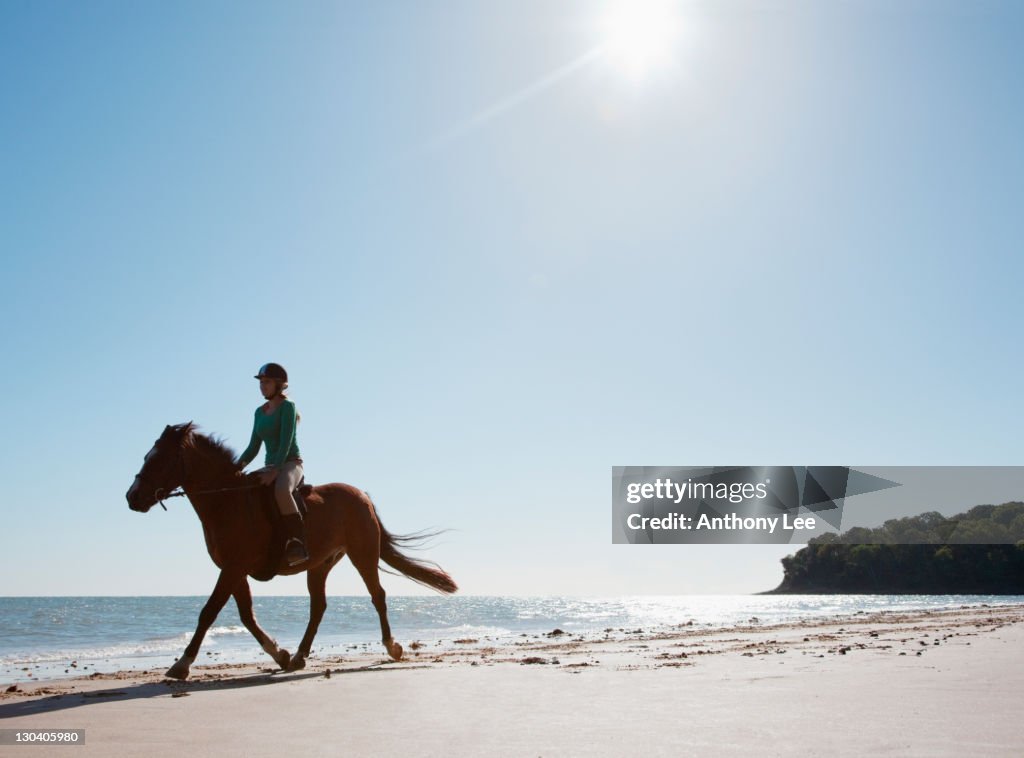 Girl riding horse on the beach