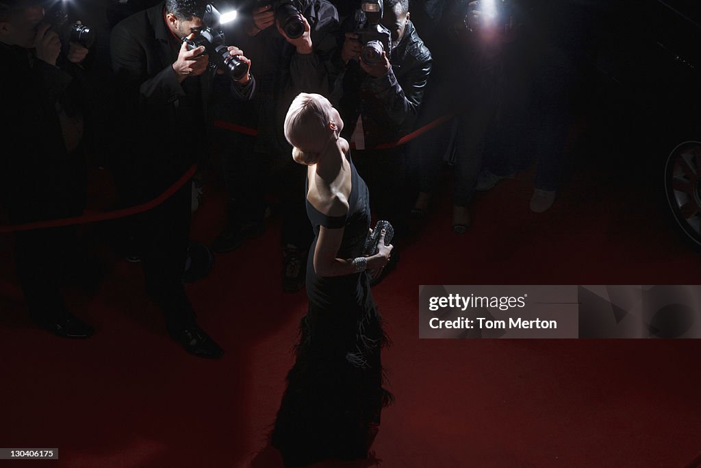 Celebrity posing for paparazzi on red carpet