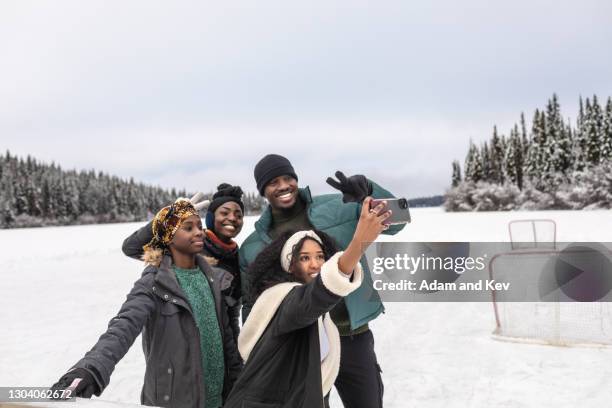 attractive group of friends pose for selfie beside frozen lake - retreat women diverse stock-fotos und bilder