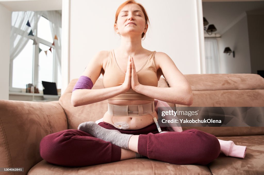 Woman making praying gesture while sitting in lotus position