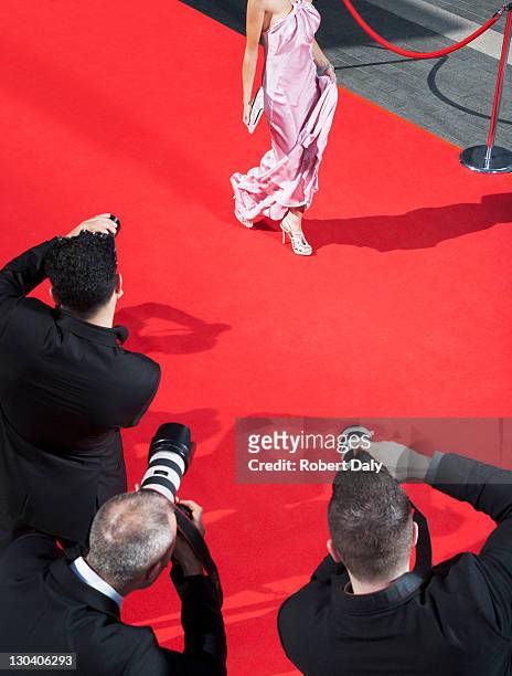 celebrity walking for paparazzi on red carpet - fame stockfoto's en -beelden