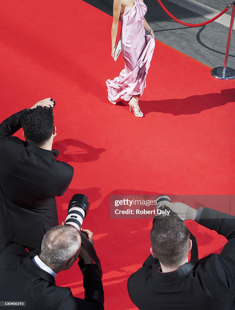 Celebrity walking for paparazzi on red carpet